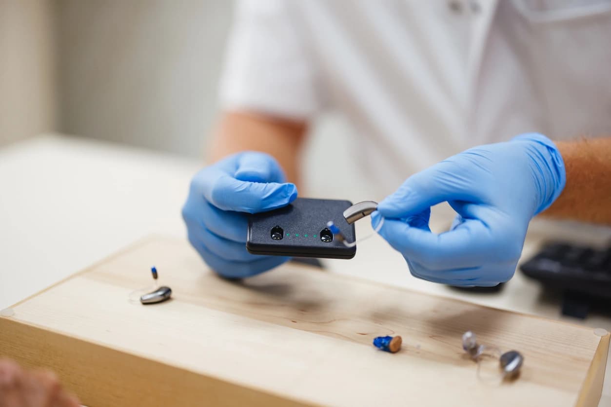 Holding hearing aids at Red Oak Hearing in Winnipeg